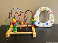 IKEA bead roller toy and Sesame Street toilet seat side by side