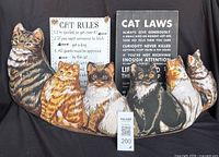 Front view of fabric cat draft stopper with two cat-themed signs