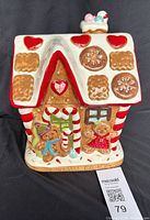 Front view of ceramic gingerbread house cookie jar with lid on