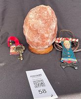 Salt lamp, door knocker, fabric doll ornament grouped on black backdrop