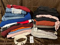 Two stacks of folded clothing, belt and lot tag