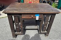front three-quarter view of desk showing top, drawer and decorative side panels