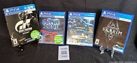 Front view of four PS4 VR game cases: Gran Turismo Sport, Battlezone, PS VR Demo Disc, Skyrim VR