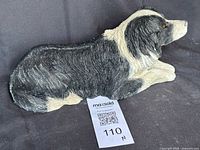 Left side view of lying border collie figurine