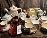 Group shot showing both teapots, sugar bowls, five teacups and saucers