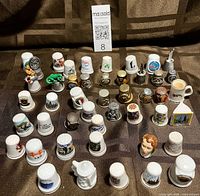 Overview of all thimbles in rows showing variety of materials and designs