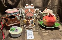 Group shot showing all teapots, apple sugar bowl, Cadbury mug, grape trinket box
