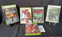 Front view of five Xbox 360 game cases: Mass Effect, NHL 08, NBA 2K12, Tetris Evolution, Bioshock