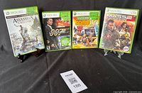 Front view of four Xbox 360 game cases lined up on black cloth