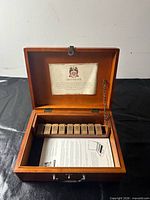 Open wooden case showing numbered tiles and instructions