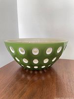 Side view of green Guzzini Le Murine bowl showing white circular insets