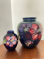 Front view of both Moorcroft Clematis vases showing floral design and relative sizes