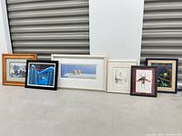 Group shot of six framed artworks lined up