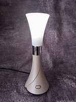 Lamp upright with diffuser lit, showing full pearl/ivory body and cord