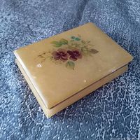 Closed alabaster box showing floral lid design and overall color