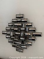 Full view of welded metal wall sculpture hung on wall