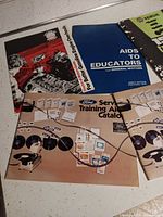 Group of catalogs showing Ford, GM and unknown training booklets