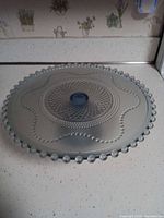 Top view showing beaded rim and patterned surface of blue glass cake stand