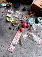 Assorted hooks, bobbers, sinkers, line spools on ground
