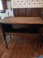 Front view of wooden side table showing open shelf and legs