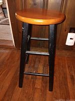 Front angle view of stool showing seat, legs, height