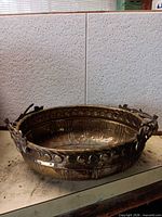 Full view of oval brass bowl showing pierced rim and handles