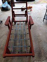 Full view of red wooden chaise lounge frame without cushions