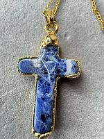 Blue sodalite cross pendant in gold-tone bezel.