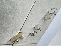 Three pairs of cufflinks displayed vertically