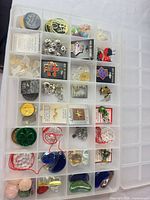 Top view of organizer showing charms, pins, stones, prisms in individual compartments