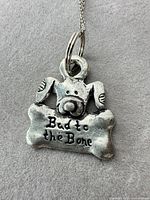 Pendant with dog head and bone motif, phrase visible