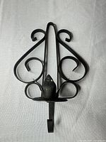 Front view of wrought iron wall sconce showing overall design and condition