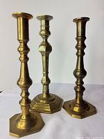 Front view of three brass candlesticks