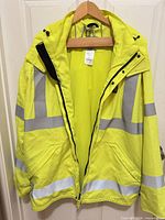 Front view of neon yellow Carhartt safety jacket with reflective stripes