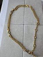 Full view of gold-tone chain belt laid flat