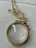 Round gold-tone magnifier pendant with chain