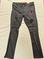 Full view of black distressed skinny jeans front side
