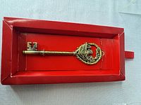 Full view of metal key ornament in red box