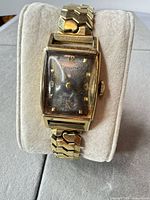 Front view of Hamilton rectangular wristwatch on display pillow