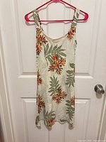 Front view of sleeveless tropical floral midi dress on hanger