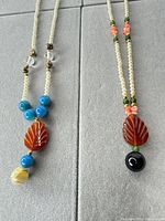 Front view of both necklaces showing bead arrangements and pendants