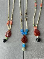 Front view of three necklaces showing bead arrangement and pendants