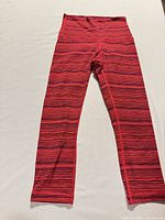 Full view of red striped Lululemon leggings laid flat