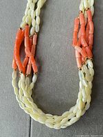 Closeup of ivory shell and coral branch beads with gold spacers