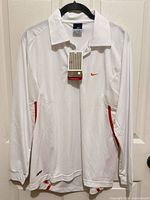Front view of white Nike long sleeve polo with tags visible