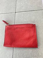 Front view of red leather coin purse showing Osgoode Marley logo embossing