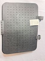 Front view of single gray felt board with perforations, hinge and strap visible, tag attached