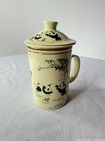 Mug assembled with lid showing panda motif and gold trim