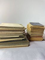 Two stacks of vintage photo folder mounts in assorted colors
