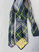 Full length of tie showing plaid pattern and brand loop label